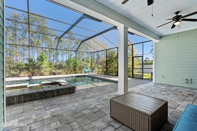 view of patio featuring ceiling fan, a swimming pool with hot tub, and glass enclosure