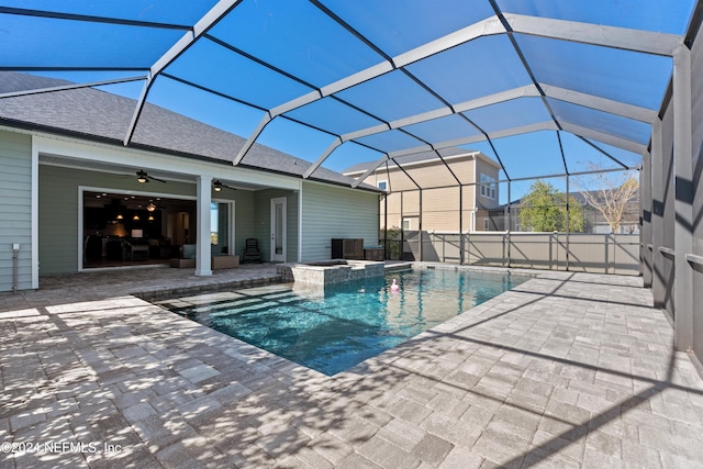 view of swimming pool with a patio, glass enclosure, and ceiling fan