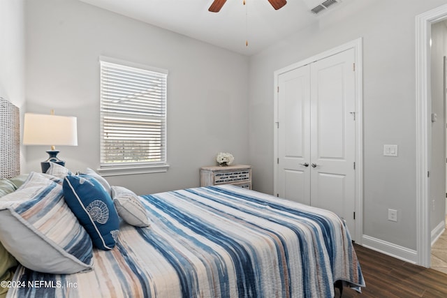 bedroom featuring a closet, dark wood-type flooring, and ceiling fan