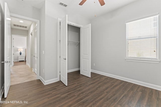 unfurnished bedroom featuring dark hardwood / wood-style floors, ceiling fan, and a closet