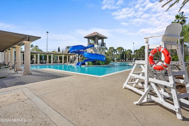 view of swimming pool with a patio area and a water slide