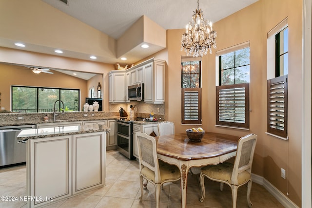 kitchen featuring plenty of natural light, decorative light fixtures, vaulted ceiling, and stainless steel appliances