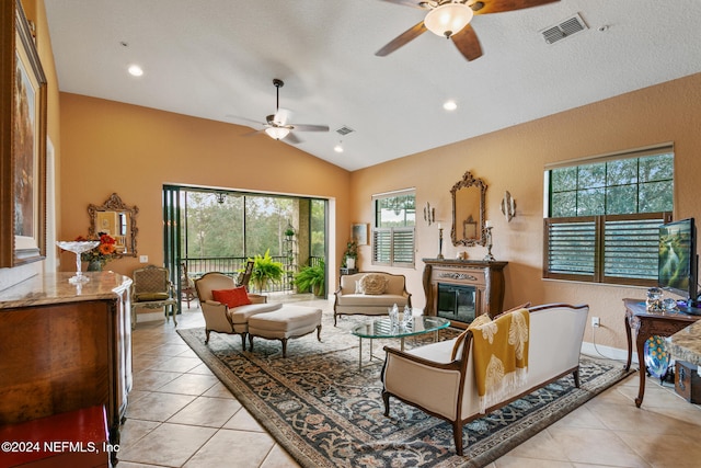 tiled living room with ceiling fan, a healthy amount of sunlight, and lofted ceiling