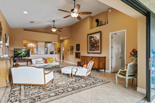 living room featuring light tile patterned flooring, ceiling fan with notable chandelier, and high vaulted ceiling