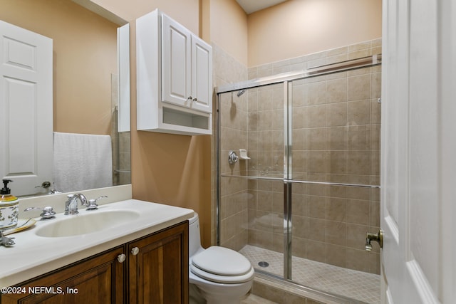 bathroom with a shower with shower door, vanity, and toilet