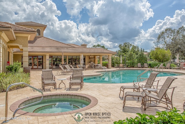 view of swimming pool featuring a community hot tub and a patio area