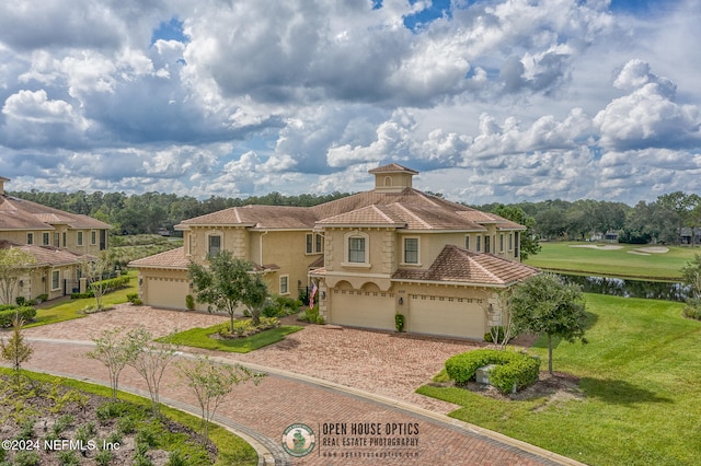 mediterranean / spanish-style house with a front lawn, a garage, and a water view