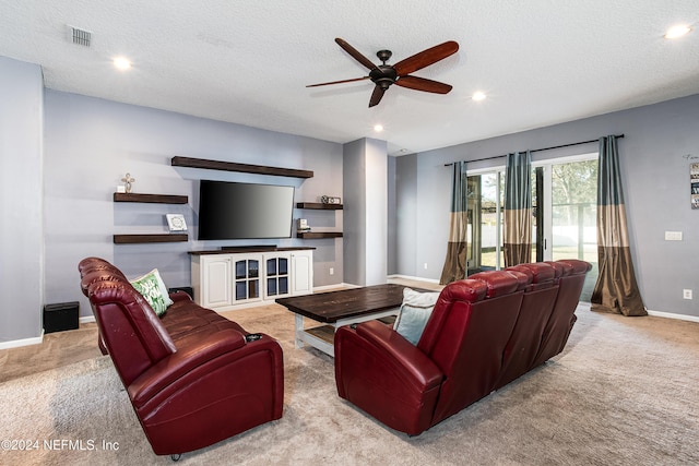 living room featuring a textured ceiling, light colored carpet, and ceiling fan