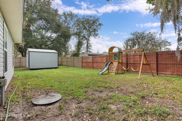 view of yard with a storage shed and a playground