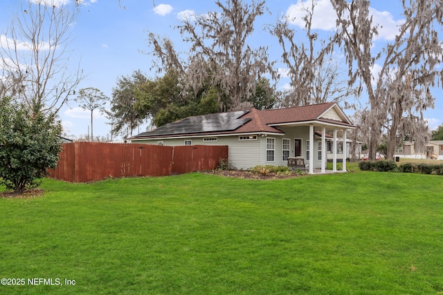 view of side of property with a lawn and solar panels