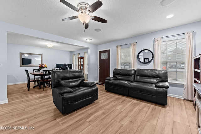 living room featuring ceiling fan and a textured ceiling