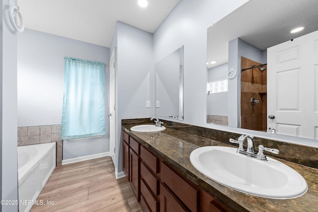 bathroom with vanity, separate shower and tub, hardwood / wood-style floors, and a textured ceiling