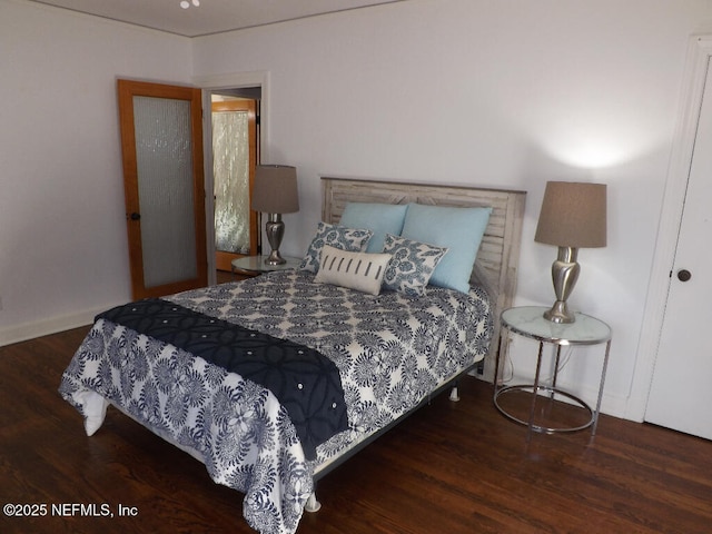 bedroom with baseboards and wood finished floors