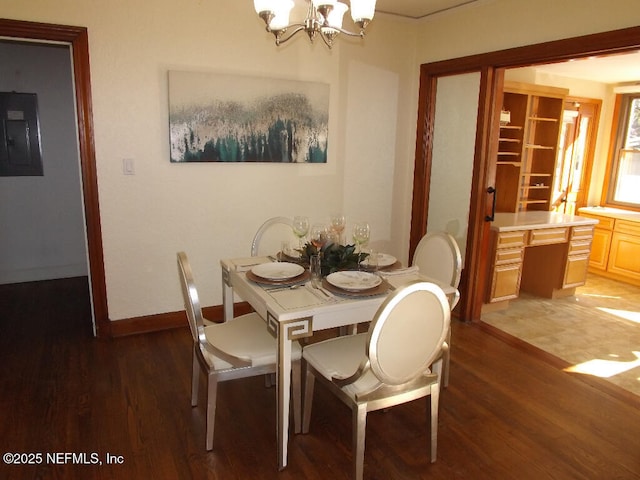 dining space featuring light wood-type flooring, an inviting chandelier, electric panel, and built in desk