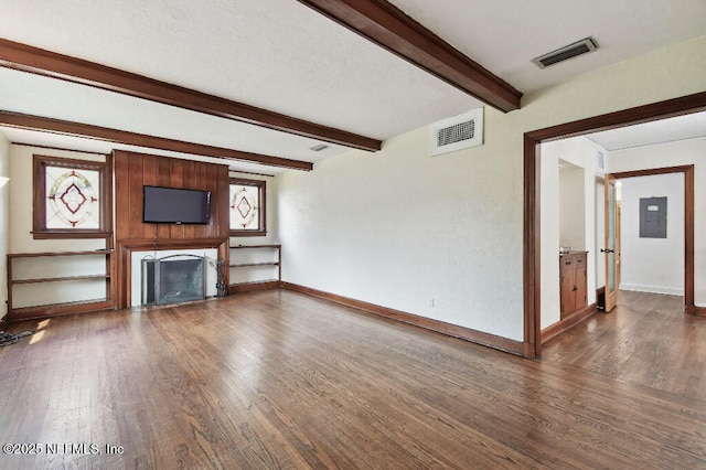 unfurnished living room with dark wood-style flooring, visible vents, and electric panel