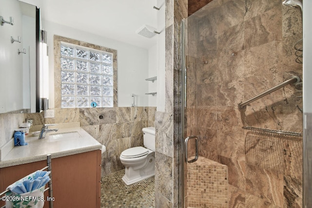 full bath with tile walls, visible vents, toilet, a shower stall, and vanity