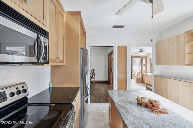 kitchen featuring stainless steel appliances, stone countertops, visible vents, and light brown cabinetry