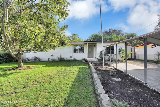 ranch-style house with a front lawn and an outbuilding