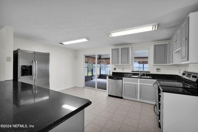 kitchen with light tile patterned floors, gray cabinetry, sink, and appliances with stainless steel finishes