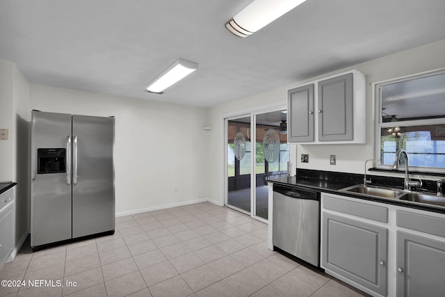 kitchen featuring a wealth of natural light, gray cabinetry, appliances with stainless steel finishes, and sink