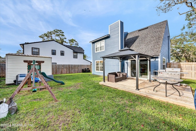 rear view of house with a playground, a yard, a gazebo, and a wooden deck