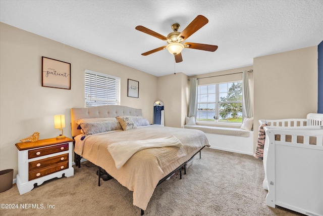 carpeted bedroom featuring a textured ceiling and ceiling fan