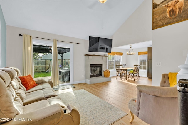 living room featuring light wood-type flooring, a chandelier, and high vaulted ceiling