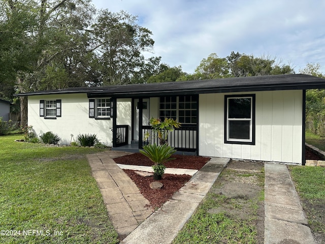 ranch-style house featuring a front yard and covered porch