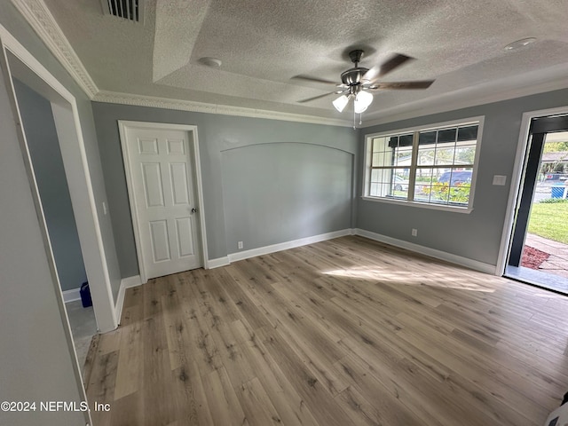 interior space with ornamental molding, light wood-type flooring, a textured ceiling, and ceiling fan