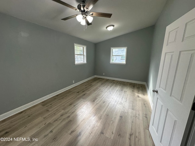 unfurnished room featuring light hardwood / wood-style flooring, ceiling fan, and vaulted ceiling