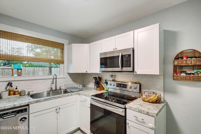 kitchen featuring backsplash, white cabinetry, sink, and stainless steel appliances