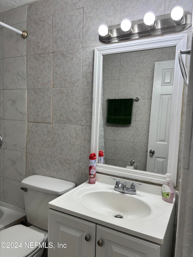 bathroom featuring vanity, toilet, and a tub to relax in