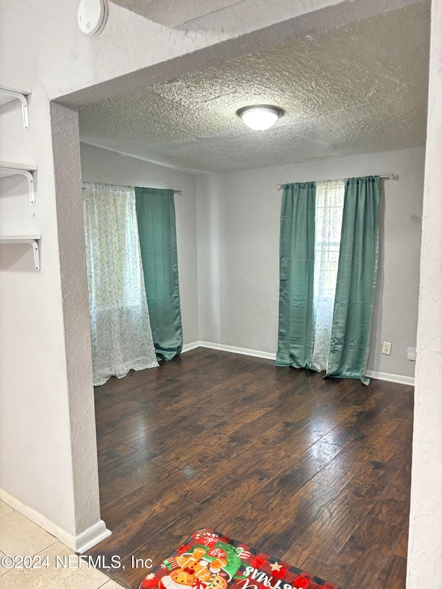 spare room with wood-type flooring and a textured ceiling