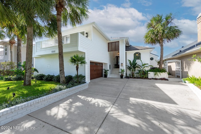 view of front of home with a garage and a balcony