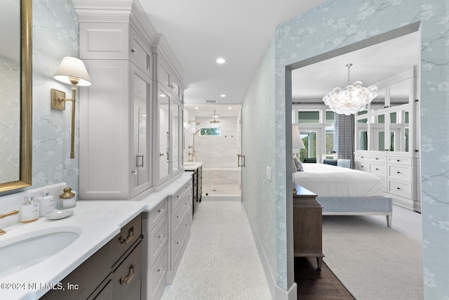 bathroom featuring vanity, a shower with door, and a notable chandelier