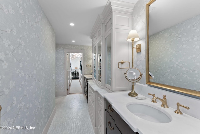 bathroom with vanity, washing machine and dryer, and tile patterned flooring