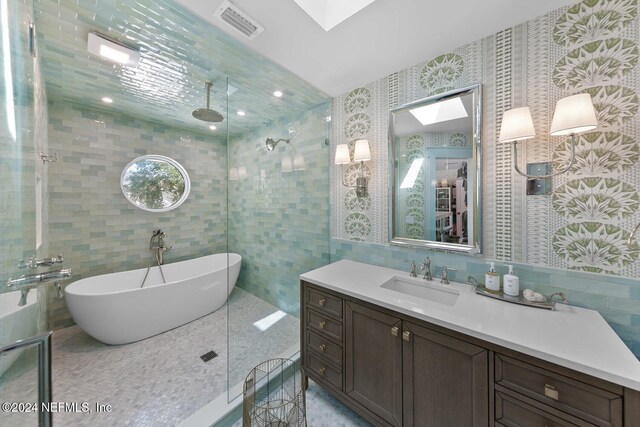 bathroom featuring a skylight, vanity, and tile walls