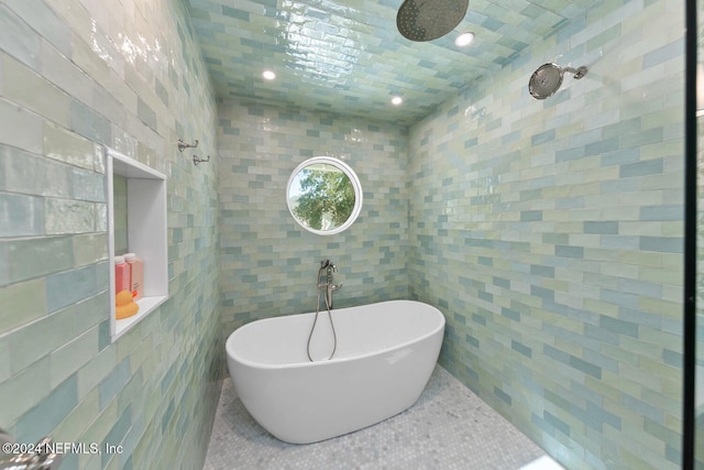 bathroom featuring a bathtub and tile walls