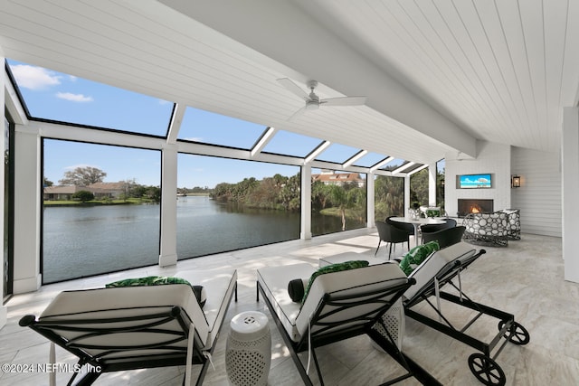 sunroom / solarium featuring a fireplace, lofted ceiling with beams, a water view, and plenty of natural light