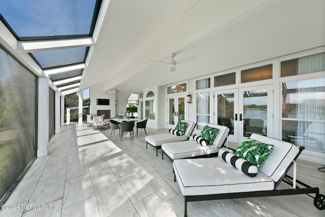 view of patio / terrace with an outdoor living space with a fireplace, ceiling fan, and french doors