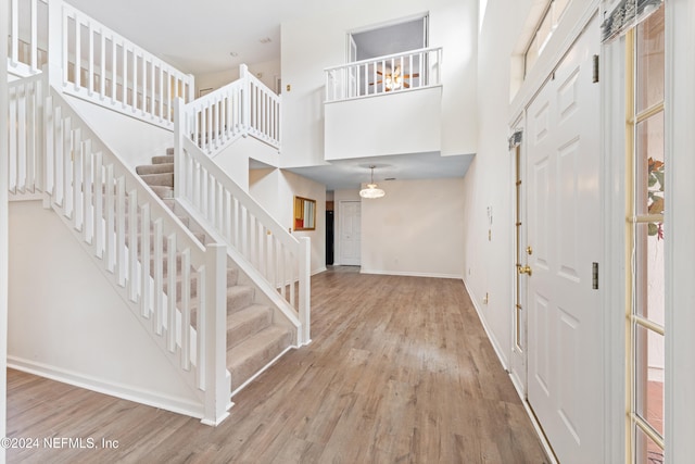 entrance foyer featuring hardwood / wood-style flooring and a towering ceiling