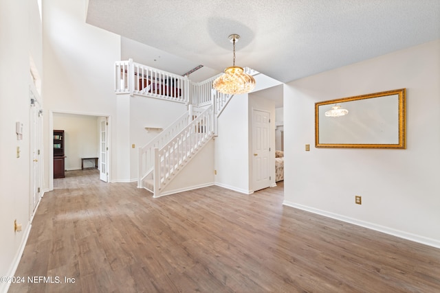 unfurnished living room with wood-type flooring and a textured ceiling