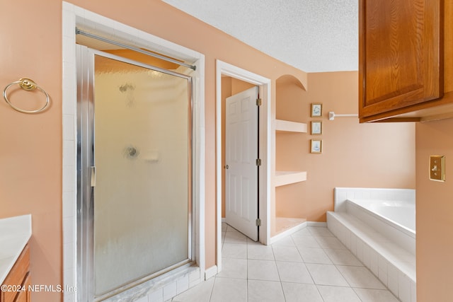 bathroom with vanity, a textured ceiling, tile patterned flooring, and separate shower and tub