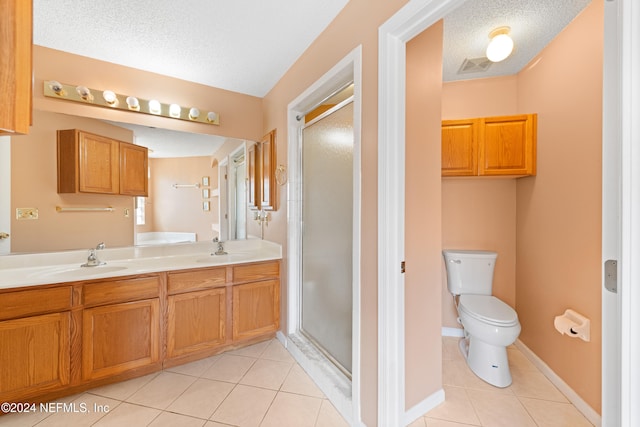 bathroom featuring a shower with shower door, a textured ceiling, toilet, and tile patterned flooring