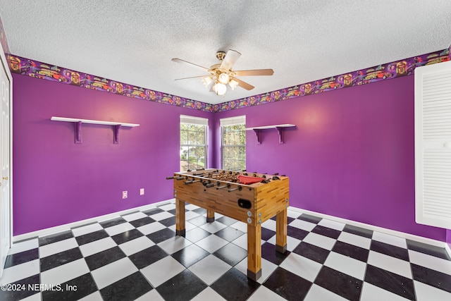 game room with a textured ceiling and ceiling fan