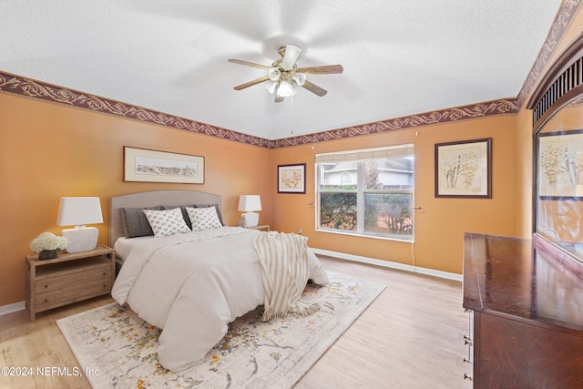 bedroom featuring light hardwood / wood-style floors, a textured ceiling, and ceiling fan