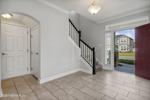 tiled foyer entrance with crown molding