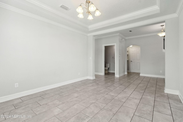 unfurnished room featuring ornamental molding, a notable chandelier, and a tray ceiling