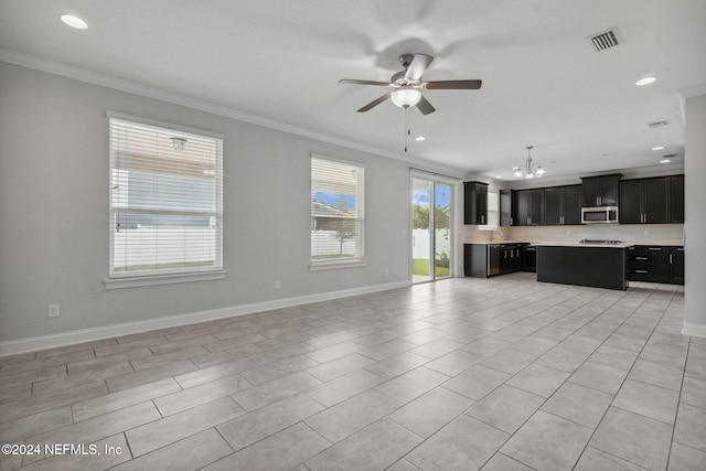 unfurnished living room featuring ceiling fan with notable chandelier, light tile patterned floors, and crown molding