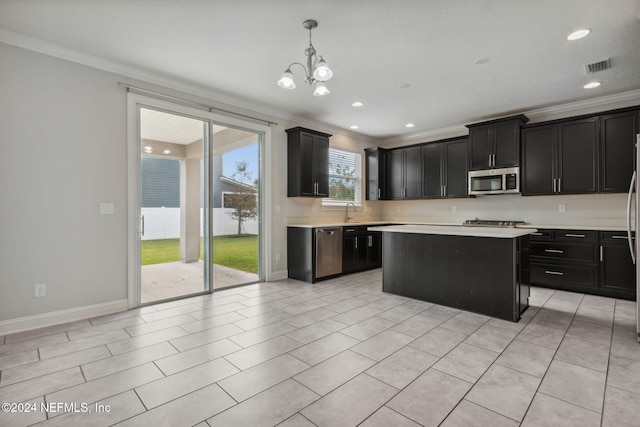 kitchen featuring crown molding, pendant lighting, appliances with stainless steel finishes, and a center island